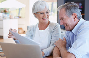 Couple smiling and reviewing bills