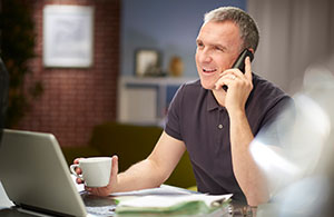 ai_ho_managebill_4 Man on phone while holding coffee cup