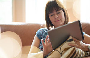 ai_ho_pickingoilcompany_4 Woman on sofa looking at iPad
