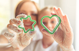 Mother and daughter holding cookie cut outs