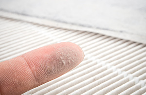 Finger wiping dust from vent