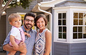 ai_whatserviceneed2 Couple with baby smiling in front of their home