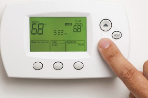 Person adjusting their thermostat